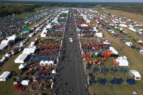 Widok z drona na teren Agroshow 2025 – setki stoisk targowych, maszyny rolnicze i tłumy odwiedzających, rozległy parking w tle
