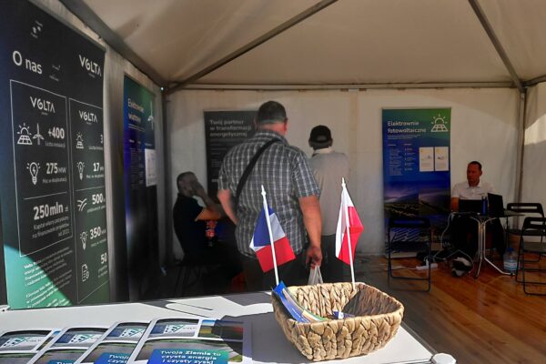 Rozmowy z klientami na stoisku Volta Polska podczas Agroshow 2025 – materiały informacyjne, flagi Polski i Francji na stanowisku, goście zapoznają się z ofertą firmy