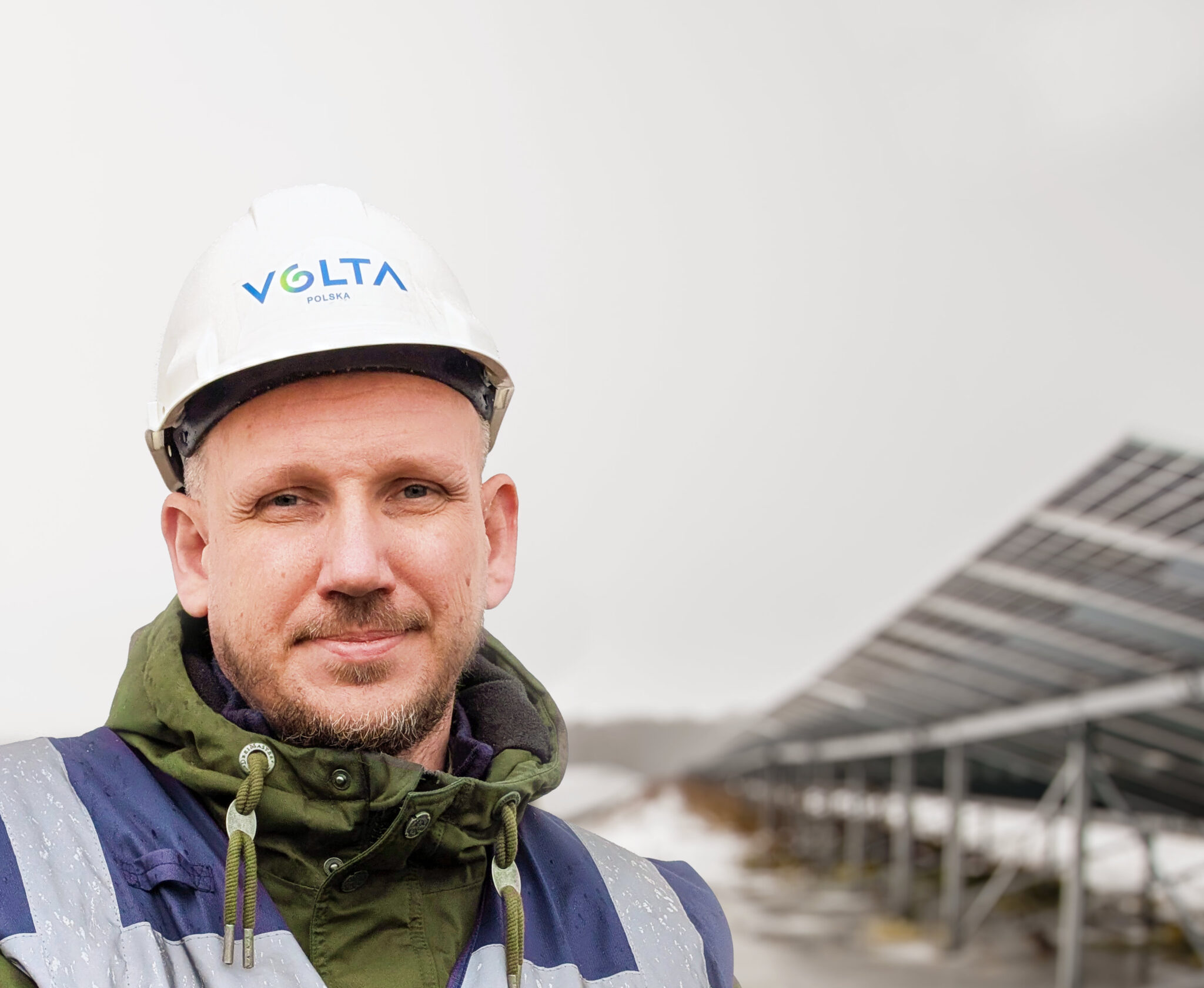 Portrait of Michał Turowski, Business Development Manager at Volta Polska, standing in front of a photovoltaic solar installation